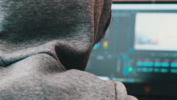 Mulher Editor de Vídeo em um Cap Senta-se em um Laptop em casa e processa a filmagem de vídeo — Vídeo de Stock