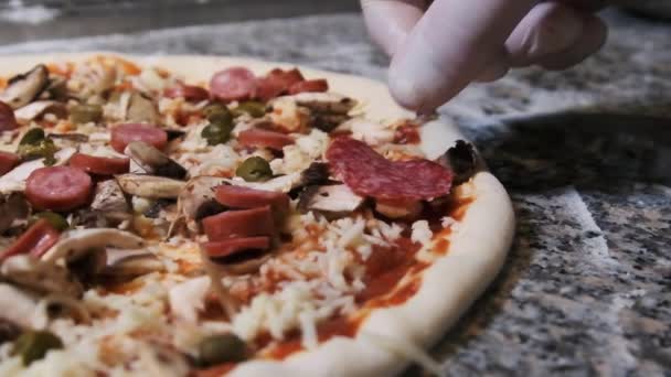 Chef Hand Deliciosamente pone Salchichón en rodajas en la Pizza. Moción lenta — Vídeo de stock
