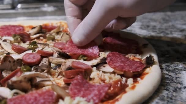 Chef Hand Pysznie Umieszcza plasterki kiełbasy Salami na pizzy. Zwolniony ruch — Wideo stockowe