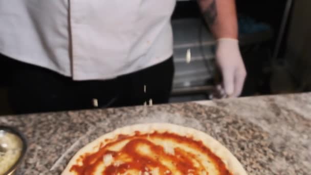 La mano del chef Deliciosamente arroja las rebanadas de queso en la pizza. Moción lenta — Vídeos de Stock