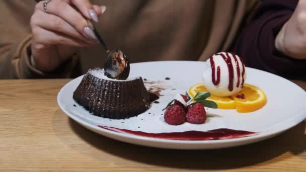 Дівчата їдять солодкий десерт у ресторані. Шоколадний фондант. — стокове відео