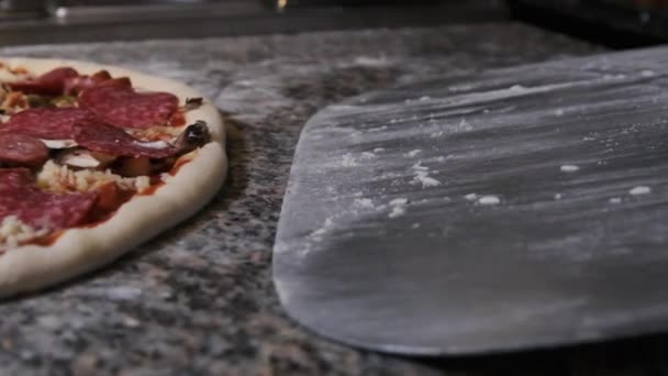 Şef, pişmiş pizzayı almak için bir Spatula kullanıyor. Yavaş Hareket — Stok video