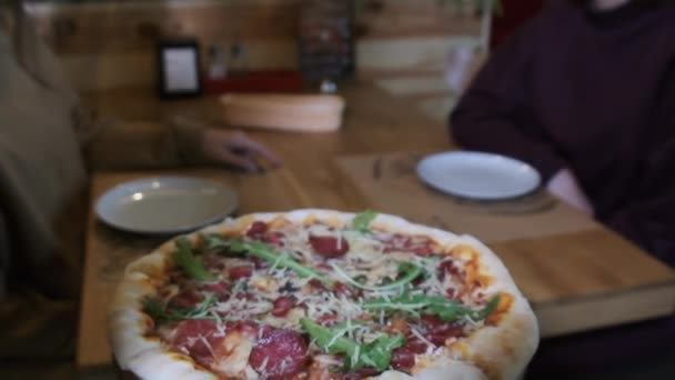 POV Waiter lleva la pizza en bandeja de madera a los clientes del restaurante. Moción lenta — Vídeos de Stock