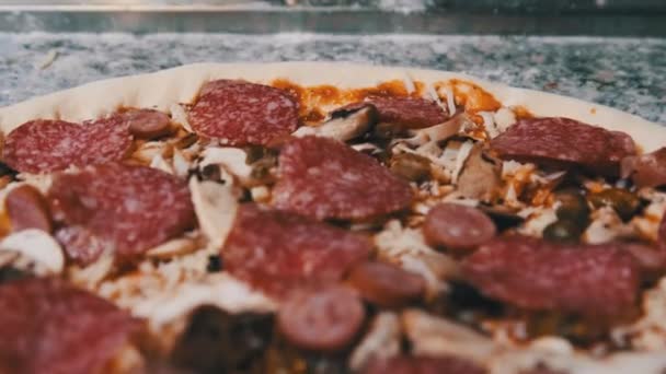 Étvágygerjesztő nyers pizza tészta apróra vágott összetevőkkel Hazugságok a konyha felületén. — Stock videók