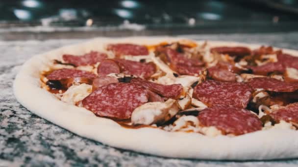 Pasta per pizza cruda appetitosa con ingredienti tritati sdraiati sulla superficie della cucina. — Video Stock