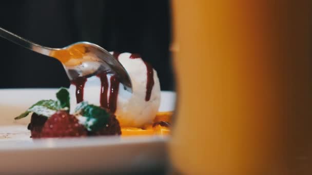 Девушка ест сладкий десерт в ресторане. Шоколадная помадка с мороженым. — стоковое видео