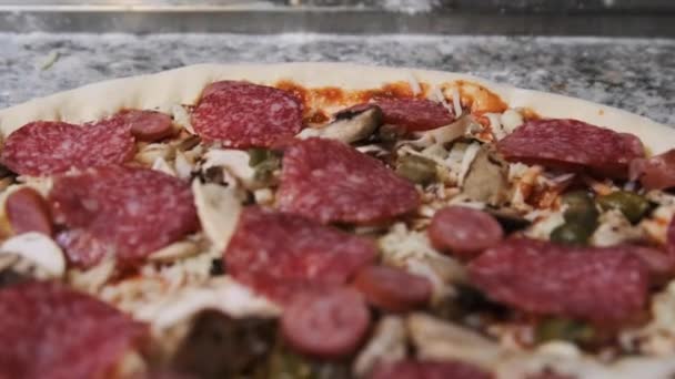 Apetyczne surowe ciasto pizzowe z posiekanymi składnikami Leży na powierzchni kuchni. — Wideo stockowe