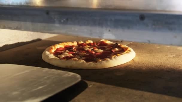 Szef kuchni używa Spatula, aby wyjąć pizzę z piekarnika w restauracji — Wideo stockowe