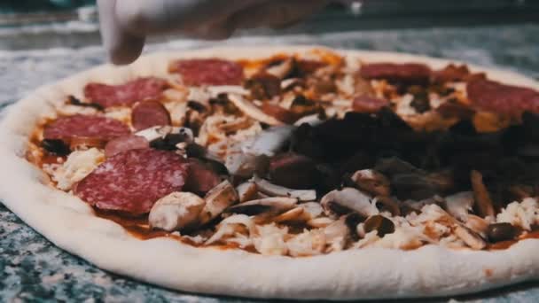 Chef Hand Pysznie Umieszcza plasterki kiełbasy Salami na pizzy. Zwolniony ruch — Wideo stockowe