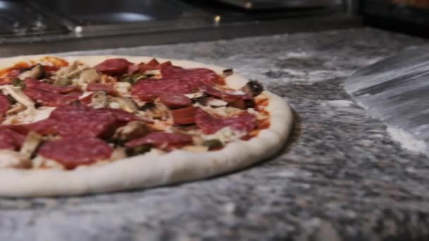 El chef usa una espátula para recoger la masa de pizza terminada para hornear. Moción lenta — Vídeo de stock