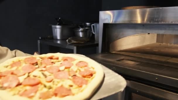 Szef kuchni na Spatula Umieszcza pizzę w nowoczesnym piecu w restauracji. Pizza do gotowania — Wideo stockowe