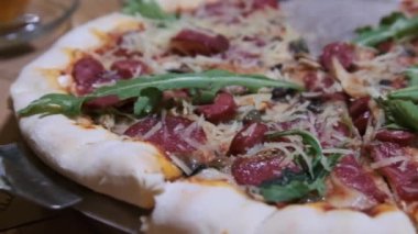 Restorandaki ahşap tabaktan pizzadan bir dilim alan kadın elleri. Yavaş Hareket