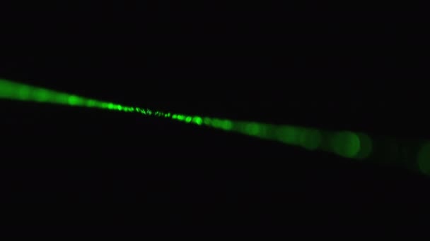 Groene laserstraal op een zwarte achtergrond. Power laserstraal schijnt in mist — Stockvideo