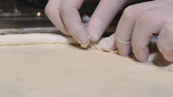Chefs Manos en Guantes Envuelva el borde del queso en la masa de pizza cruda. Moción lenta — Vídeo de stock