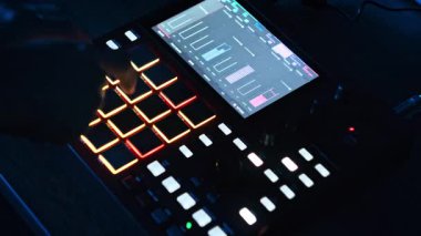 Bir sanatçı aydınlanmış pedleri manipüle eder ve kırmızı ped kontrolörünü kontrol eder. Elektronik ritimler üretir. Dinamik ortam aydınlatması, karanlık bir stüdyoda cihazın etrafındaki renkleri değiştirir..