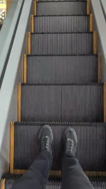 Boş yürüyen merdivenlerin yakın plan çekimi sürekli yukarı doğru hareket ediyor. Sarı güvenlik çizgileri olan yivli metal izler arka plan döngüsü için mükemmel bir ritmik ve hipnotik mekanik hareket yaratır..