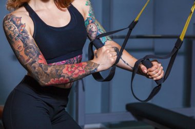 döngüler spor egzersizleri yapıyor kız. Kız fitness dövmeler ile güzel bir vücut kasları ile gösterir. Çeşitli spor malzemeleri ve fitness ekipmanları için spor ve fitness