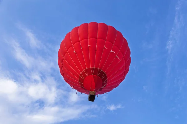 赤い風船が空を飛んでいます バスケットと風船は地面 寒くて熱い空気で気球を満たすための機器にあります 打ち上げのため バルーンを準備 — ストック写真