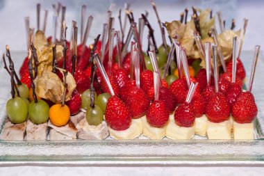 aperatifler dan meyve kivi, armut, ahududu, çilek ve üzüm için etkinlikler ve partiler küçük ahşap sopa üzerinde