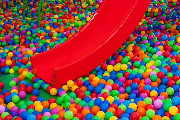 Perto de bolas de plástico coloridas na sala de jogos infantil