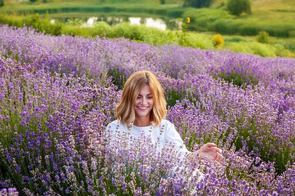 Beyaz Elbiseli Genç Kız Lavanta Çiçekleri Gülümser Oturur — Stok fotoğraf