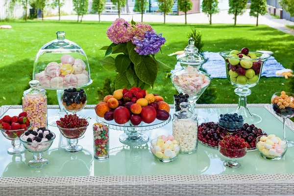 Candy bar of fruits, berries and marshmallows for a party. Festive table with sweet and fruity snacks