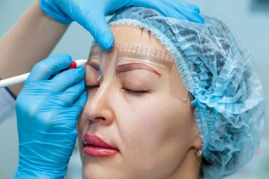 Güzellik uzmanı, kalıcı makyaj kaşlar kaşlarını üzerinde biçimlendirme uygulanır. Kaş dövme ve dudaklar