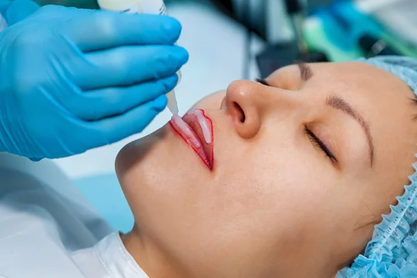 Beautician, anesthesia on the lips for permanent lip makeup. Lip tattoo