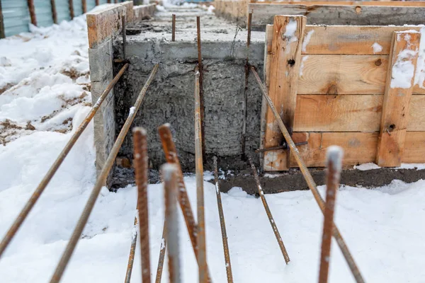 Concrete foundation, piles and metal construction on the site of a new house. The process of building a home at the initial stage.