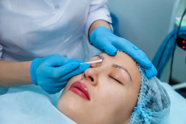 Güzellik uzmanı, kaslar üzerinde kalıcı makyaj uygulanır. Kaş ve dudak dövme