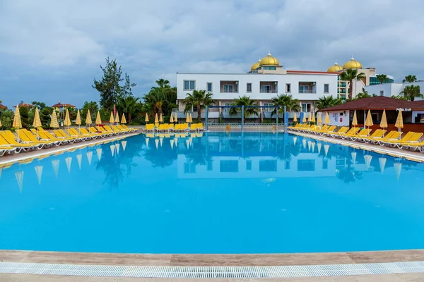 sarı şezlonglu mavi yüzme havuzu