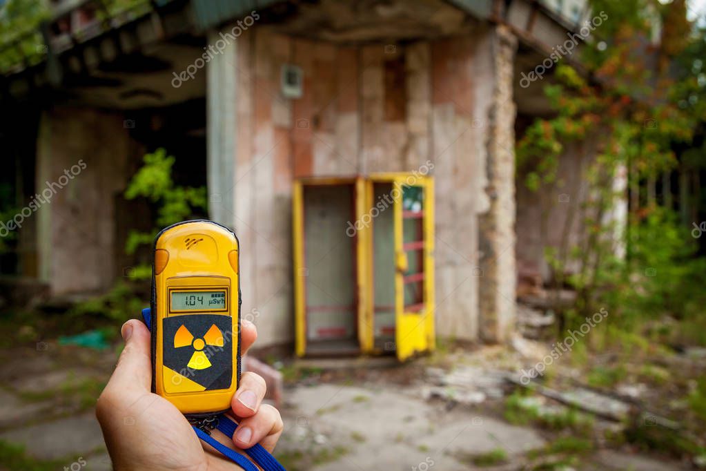 A dosimeter in hands with a level of radioactivity in the city of Pripyat, a ghost town of the Chernobyl nuclear power plant affected by a nuclear disaster in 1986, Chernobyl Exclusion Zone, Ukraine.