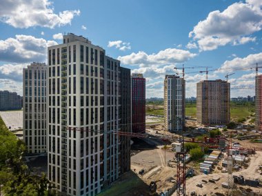 Çok katlı binalar, kule vinçleri ve inşaat ekipmanları olan bir inşaat alanı. Yüksek binaların inşaatı