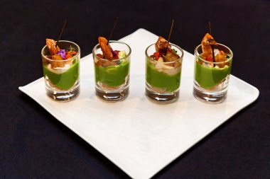 Deniz ürünleri ve yeşil makarna aperatifleri ile bardaklar etkinlikler ve açık büfe için ziyafet tabağı. Yemek servisi, ziyafet için karides atıştırmalıkları..