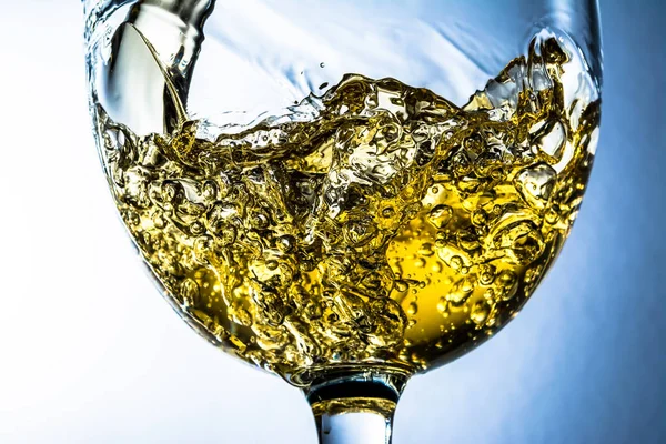 Gri arka plan, beyaz şarap bir bardak dökülen dere üzerinde beyaz şarap sıçrama. Parlak görünüm fotoğraf.