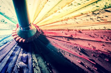 Çok renkli renkli şemsiye yağmur damlaları ile gökkuşağının bütün renkleri ile. Vintage, grunge, eski, retro tarzı fotoğraf.