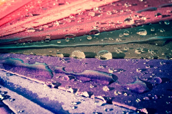 雨滴上五颜六色的雨伞上全是彩虹特写的颜色 Waterdrops 复古风格的照片 — 图库照片