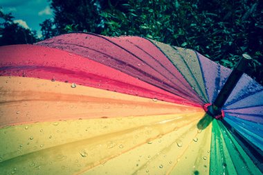 Çok renkli renkli şemsiye yağmur damlaları ile gökkuşağının bütün renkleri ile. Vintage, grunge, eski, retro tarzı fotoğraf.
