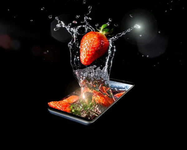 A conceptual creative 3D volumetric photo of a ripe red strawberry close-up in splashes of water and sunlight falling into the water in a smartphone isolated on a black background.