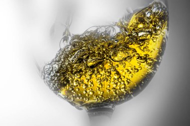 Beyaz şarap bir bardak beyaz şarap gri bir arka plan üzerinde sıçrama yakın çekim içine dökme akışı. Siyah ve beyaz fotoğraf rengine etrafında güzel sis ve şarap ile