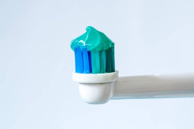 Elektrikli diş fırçası nane tat ile yeşil diş macunu ile beyaz bir arka plan üzerinde Kapat