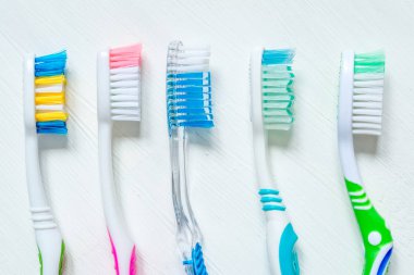 Farklı renkteki diş fırçası bir beyaz vintage zemin üzerine kapatın. Yukarıdan görüntülemek.