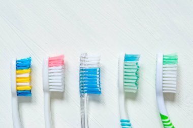 Farklı renkteki diş fırçası bir beyaz vintage zemin üzerine kapatın. Yukarıdan görüntülemek.