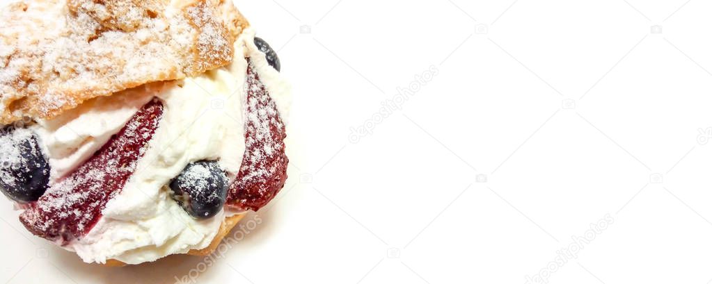 Fruit cake with american blueberries and strawberries close-up isolated on a white background with space for text.