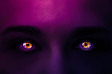 Bir kadının yüzüne degrade gelen pembe mor mor renk ve koyu renk çok renkli gözleri ile gizemli bir yoğun parlak neon ışık ile yaratıcı fotoğraf bakın. Siyah kadın gözleri yakın çekim makro parlak.