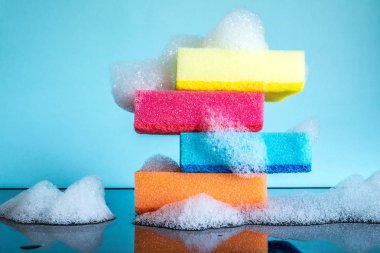 Mavi bir arka plan üzerinde köpük ve yansıma yakın çekim ile renkli süngerler