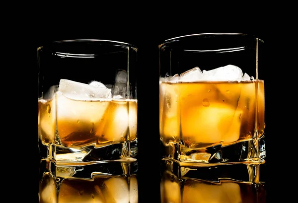 Whiskyt jéggel közelről egy üveg asztal fekete alapon elszigetelt — Stock Fotó