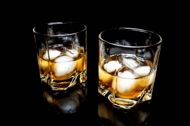 Buzlu viski yakın çekim üzerinde siyah bir arka plan üzerinde izole bir cam masa