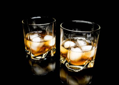 Buzlu viski yakın çekim üzerinde siyah bir arka plan üzerinde izole bir cam masa