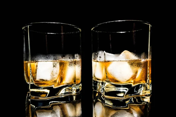 Buzlu viski yakın çekim üzerinde siyah bir arka plan üzerinde izole bir cam masa — Stok fotoğraf